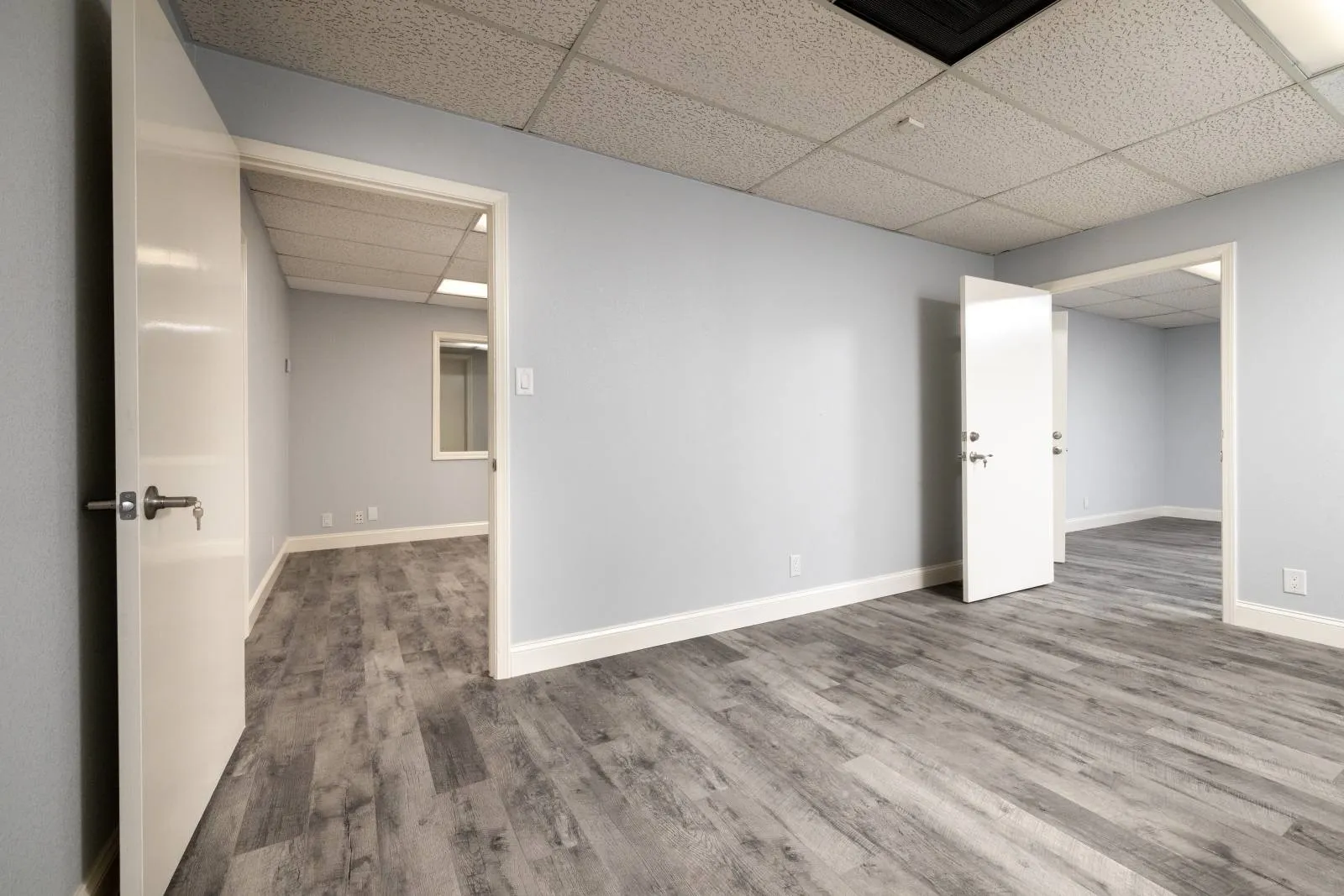 Spare room featuring wood-type flooring and a paneled ceiling