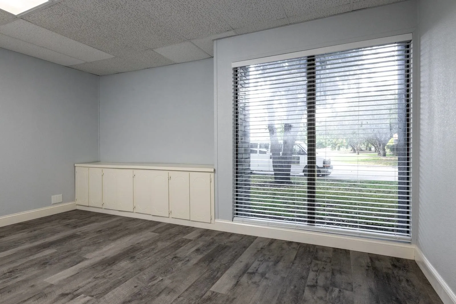 Unfurnished room featuring a drop ceiling and dark hardwood / wood-style flooring