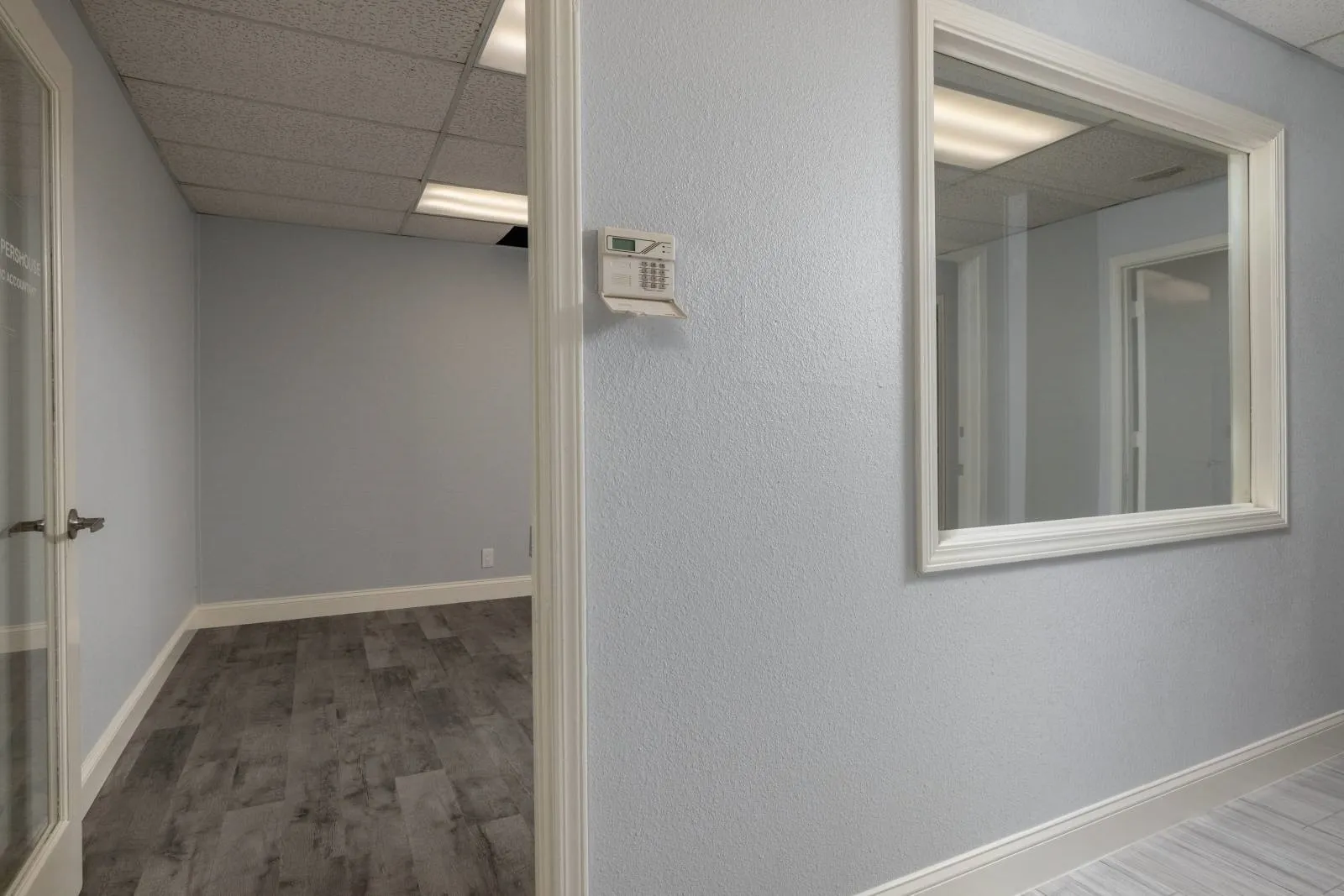 Corridor featuring a paneled ceiling and hardwood / wood-style floors
