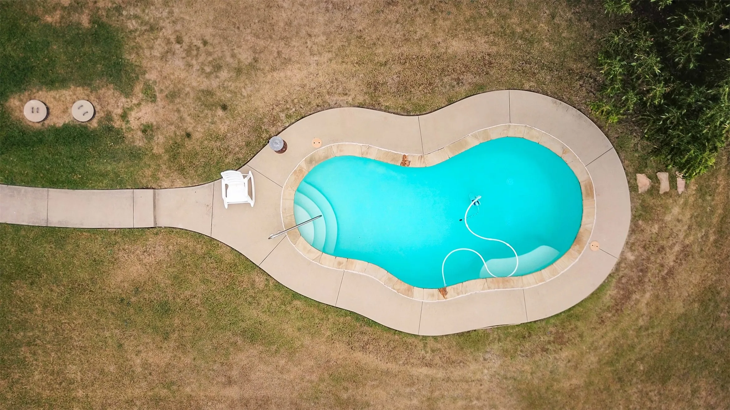 View of pool with a lawn