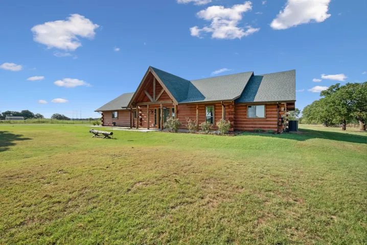 View of front of house featuring central AC and a front lawn