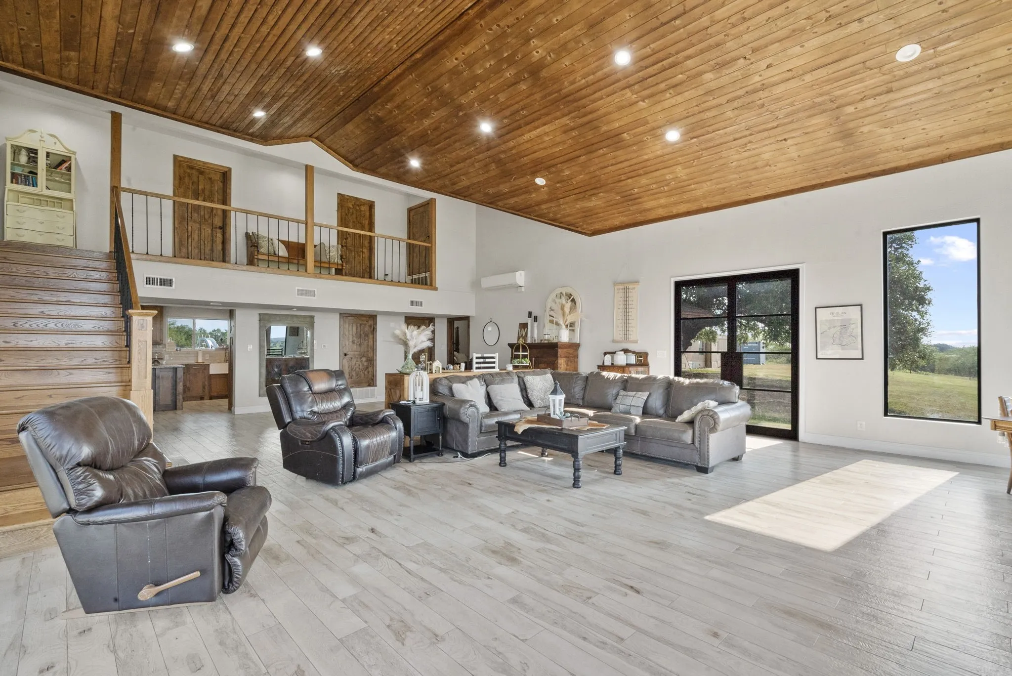 Living room with light hardwood / wood-style flooring, plenty of natural light, high vaulted ceiling, and wood ceiling