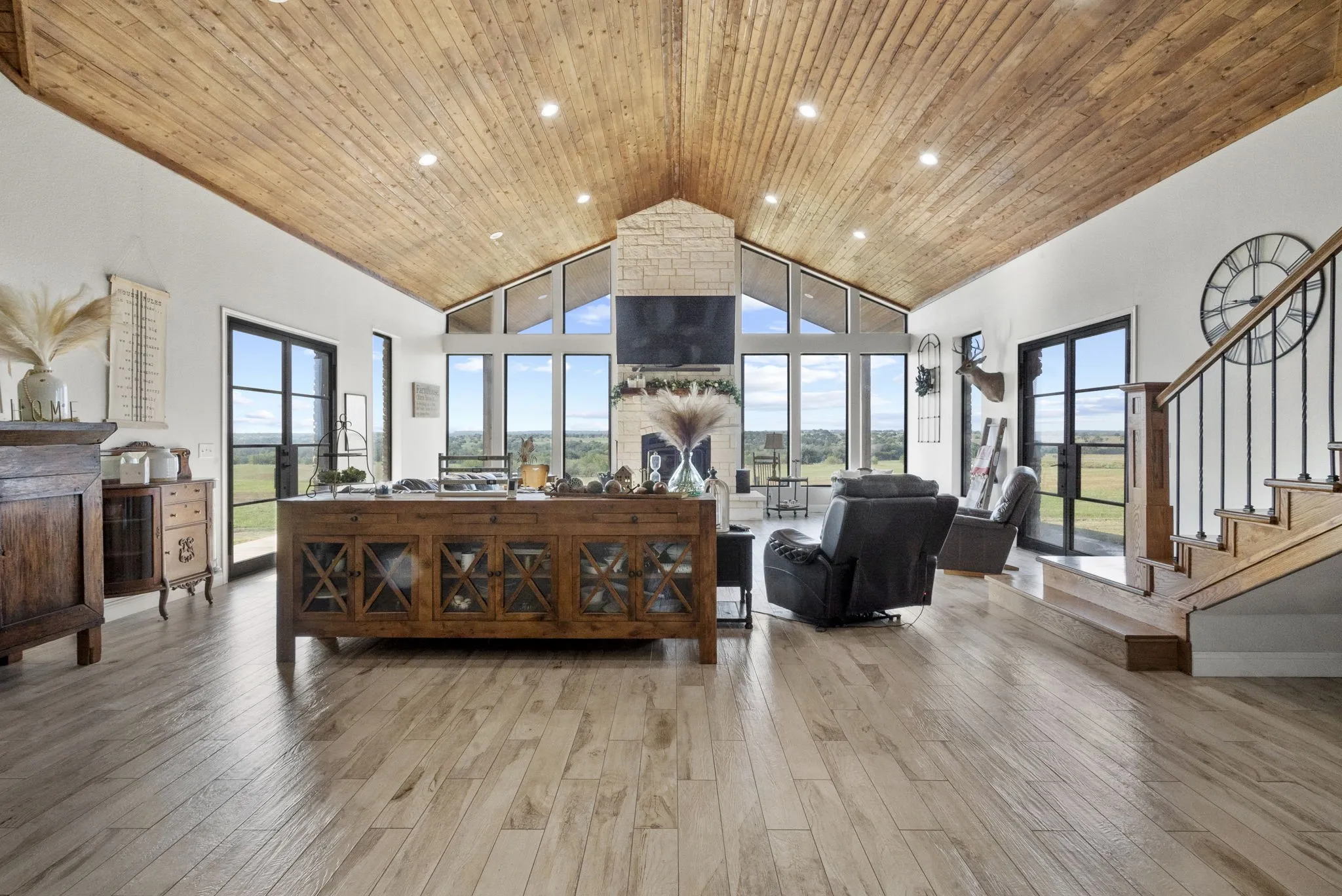 Living room with high vaulted ceiling, light wood-type flooring, and wooden ceiling