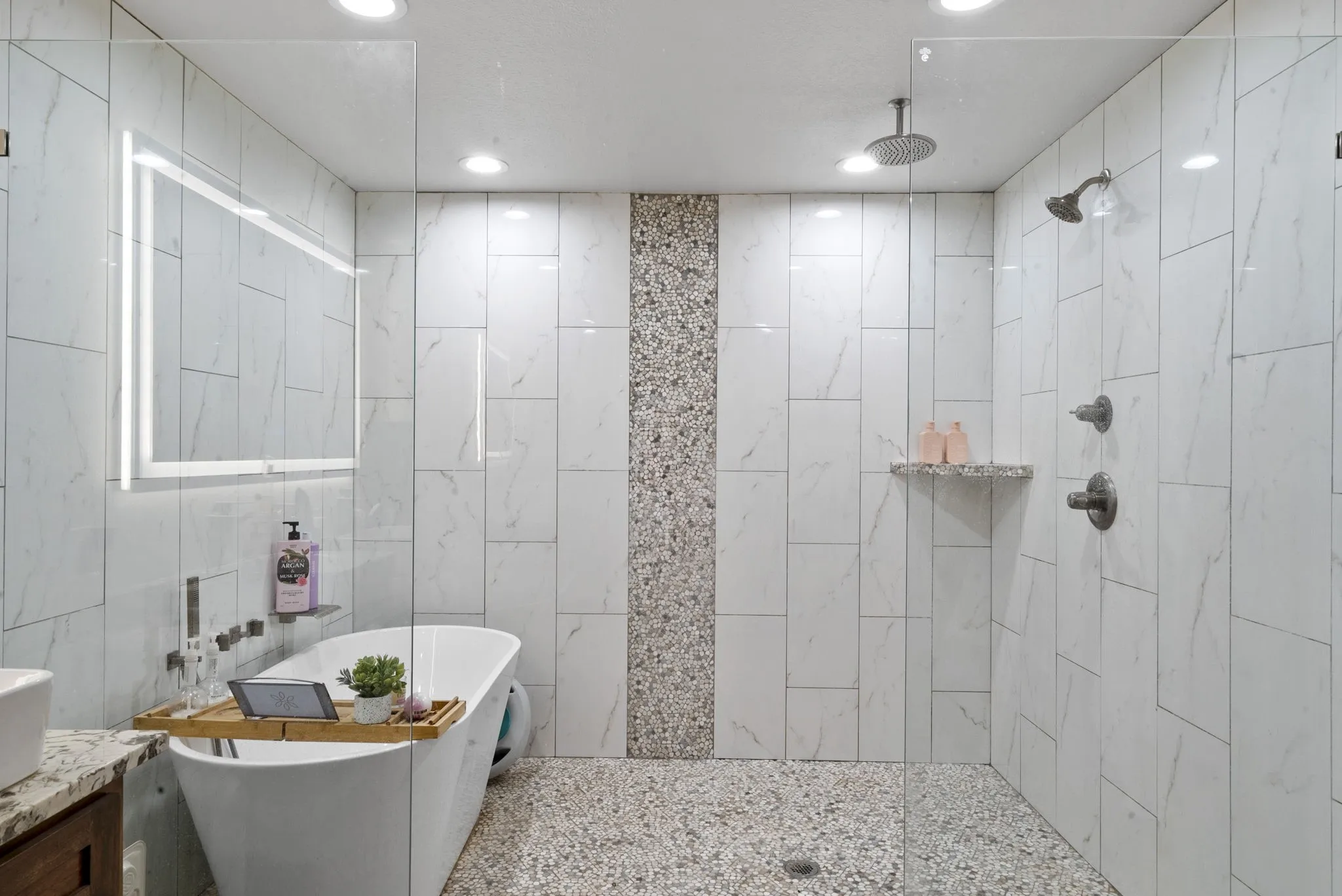 Bathroom with tile walls, independent shower and bath, and vanity