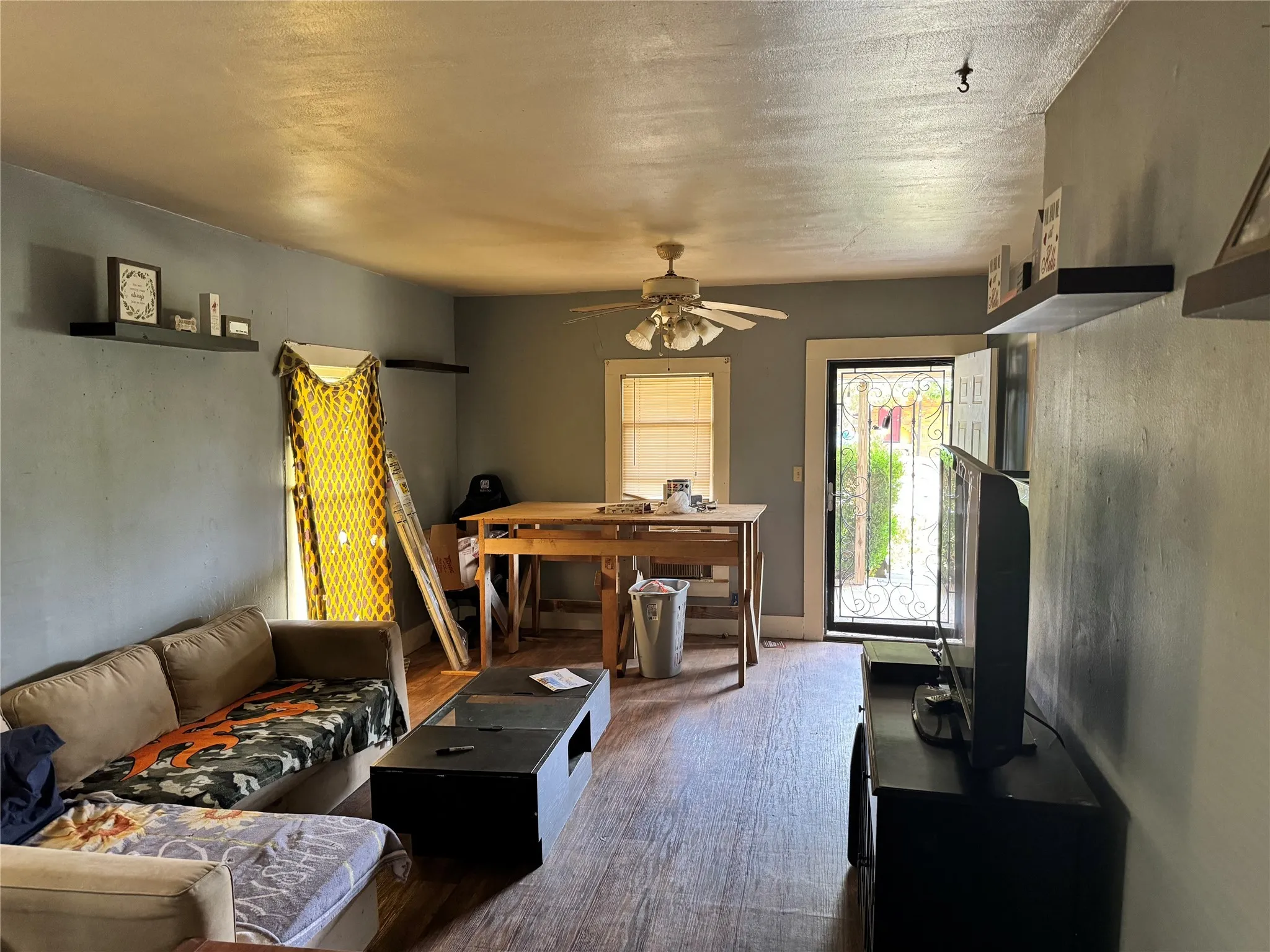 Living room featuring a textured ceiling and ceiling fan