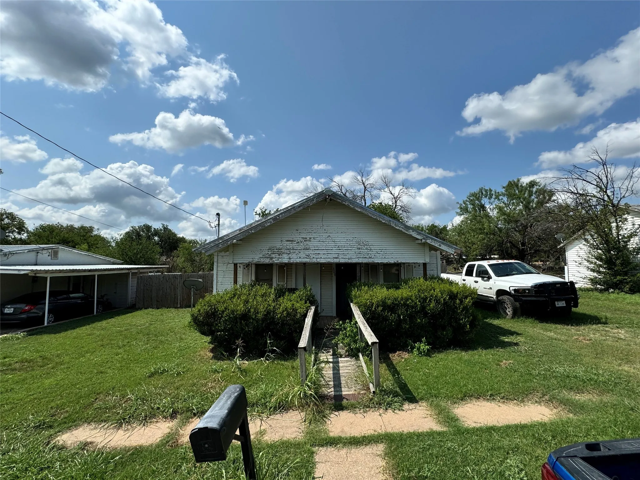 View of front facade featuring a carport and a front yard