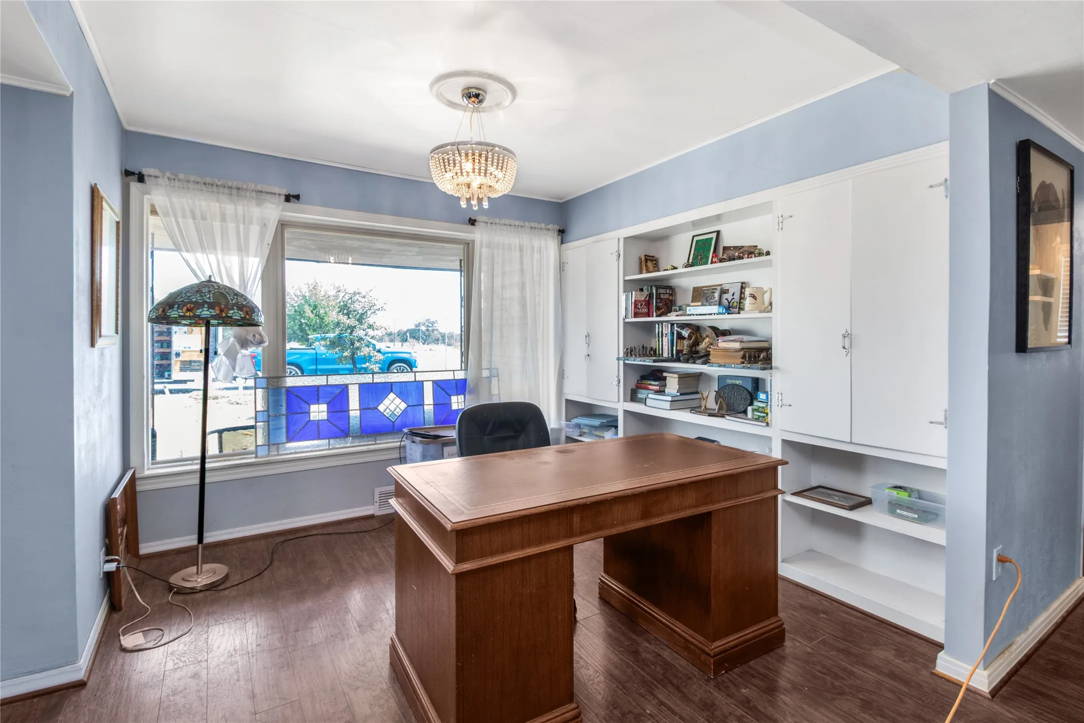 Office featuring built in shelves, plenty of natural light, dark hardwood / wood-style flooring, and a chandelier
