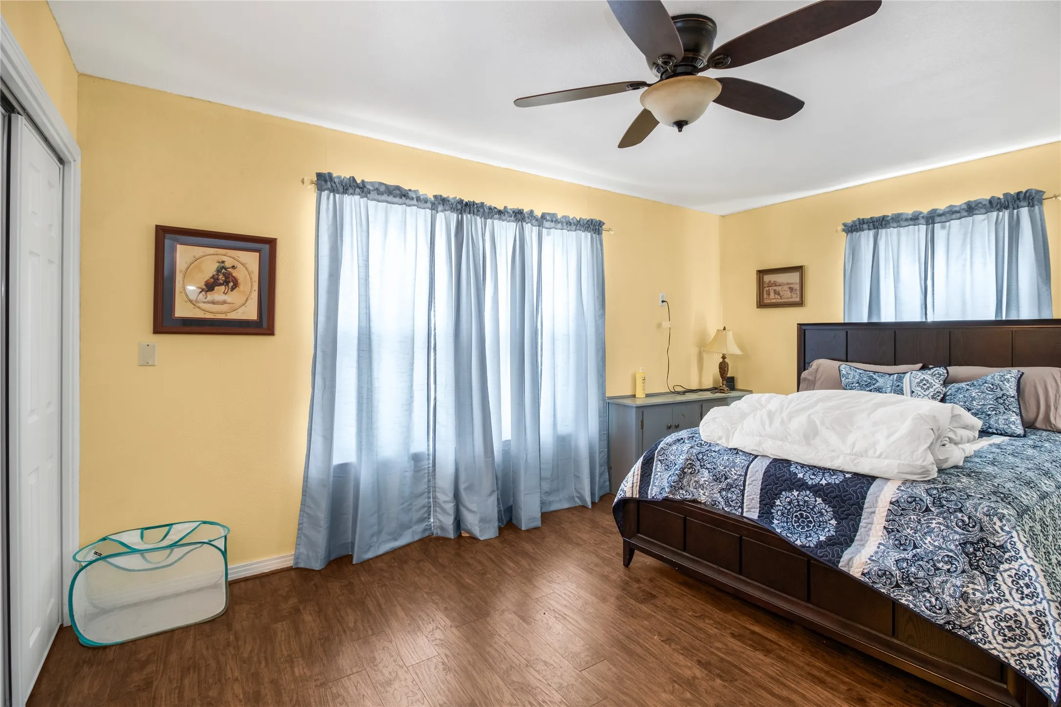 Bedroom with ceiling fan, a closet, and dark hardwood / wood-style floors