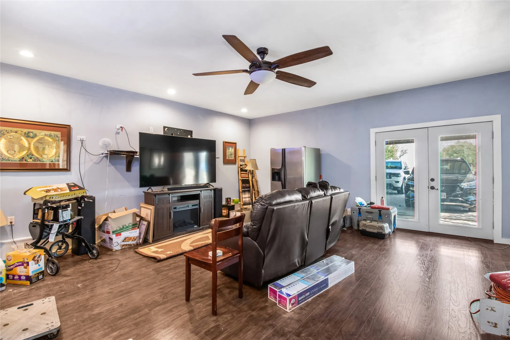Living room with hardwood / wood-style floors, french doors, and ceiling fan