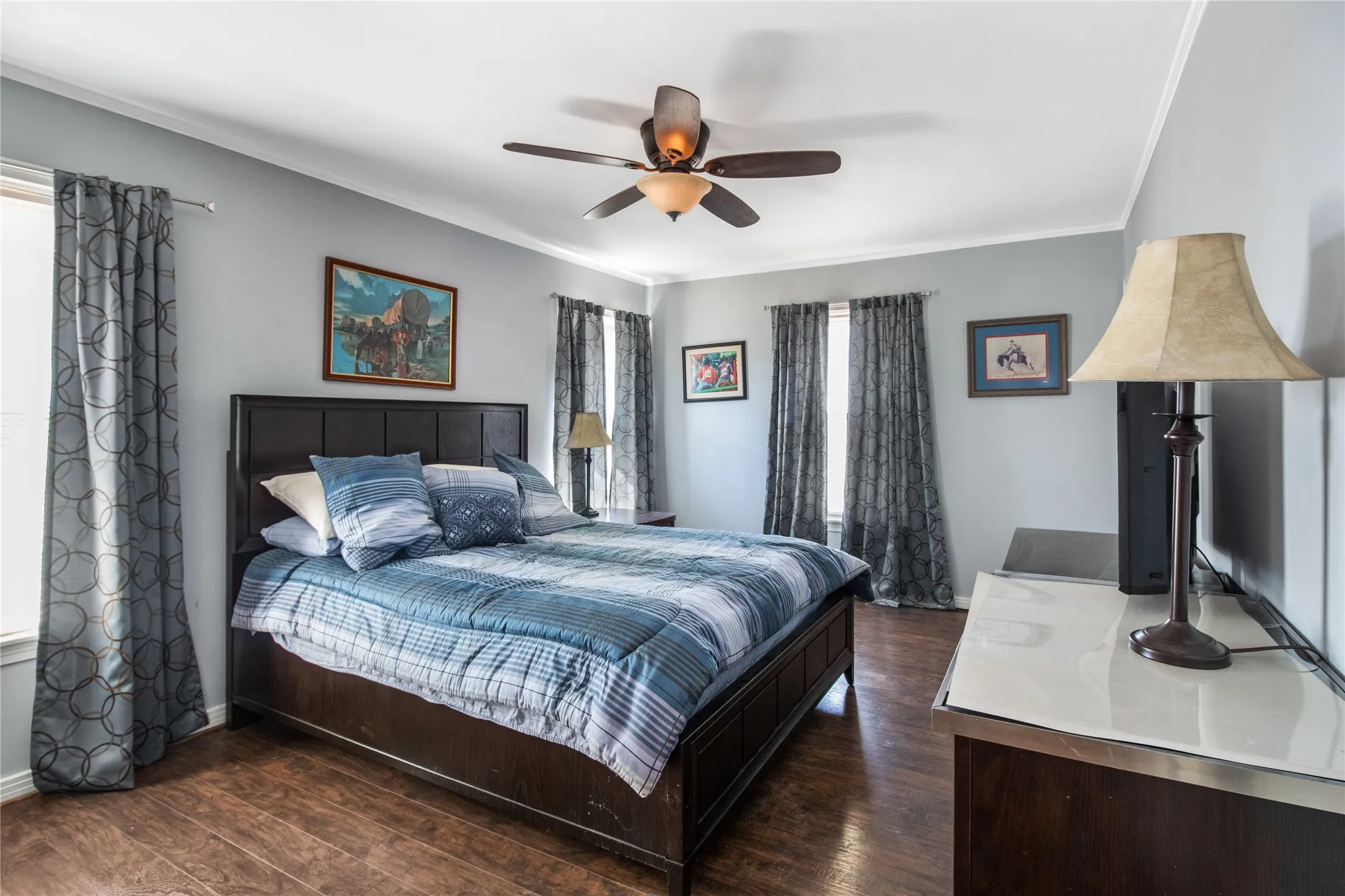 Bedroom featuring ceiling fan, dark wood-type flooring, and ornamental molding