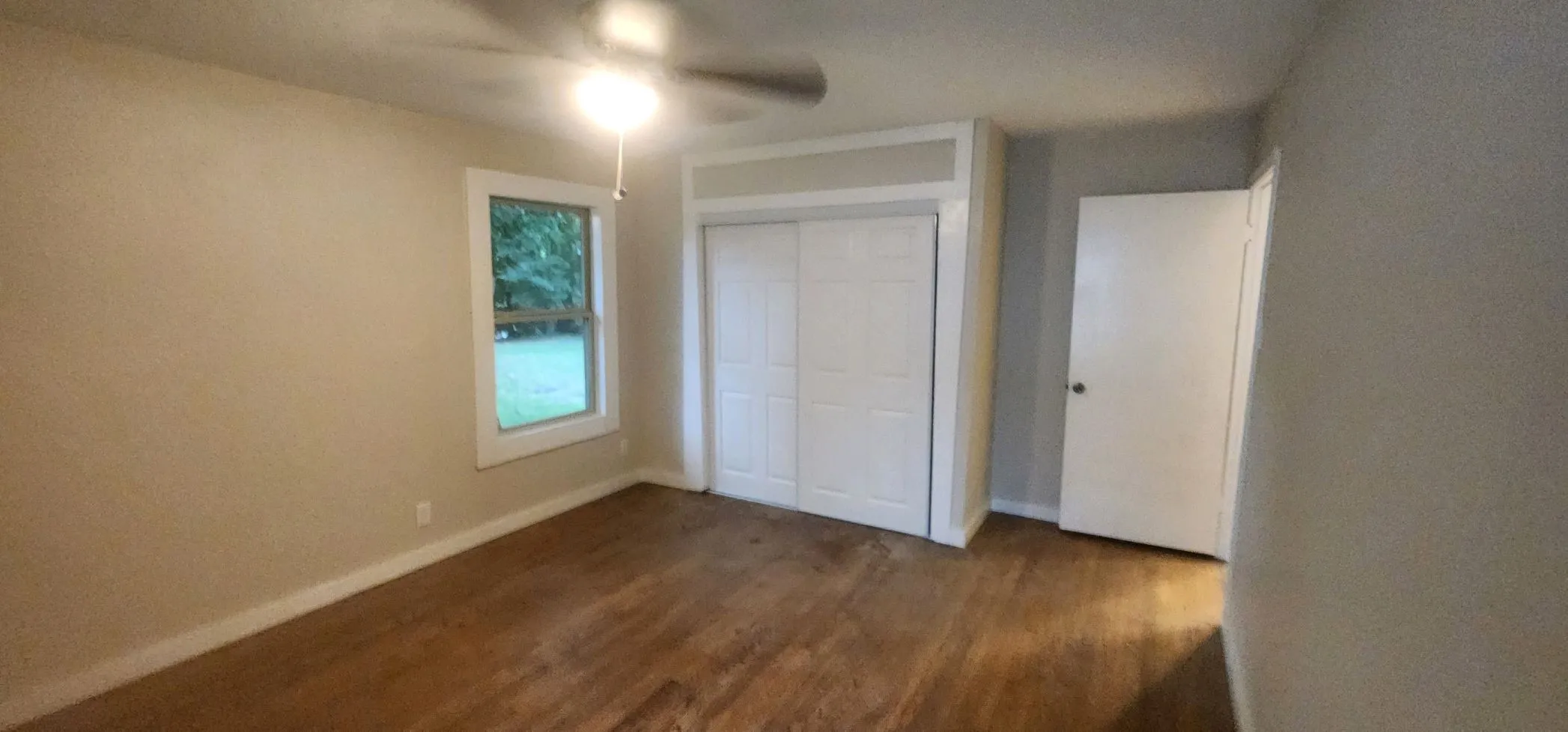 Unfurnished bedroom featuring dark hardwood / wood-style floors, a closet, and ceiling fan
