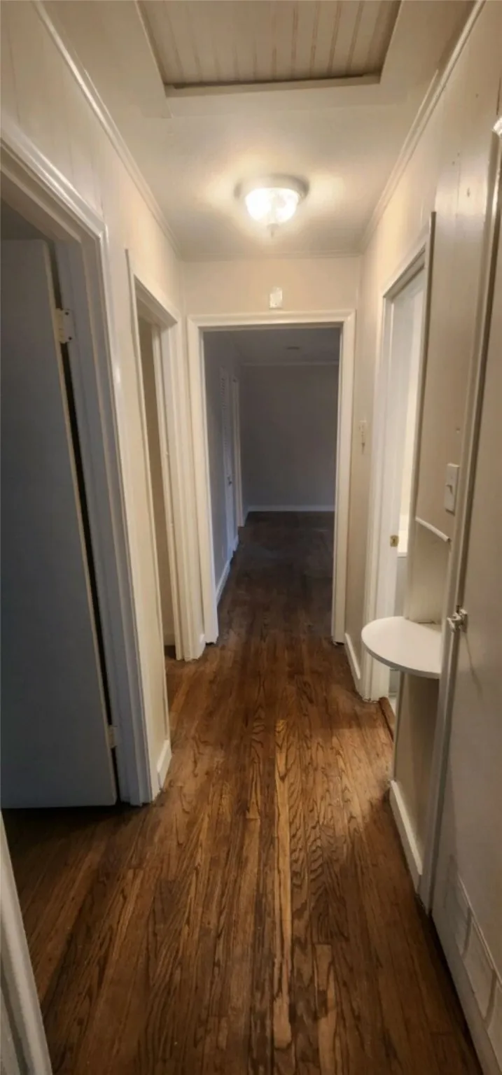 Corridor with crown molding and dark hardwood / wood-style floors