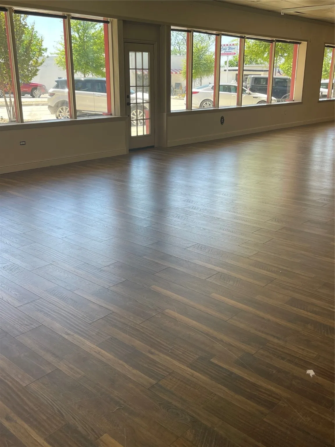 Spare room featuring dark wood-type flooring and a healthy amount of sunlight
