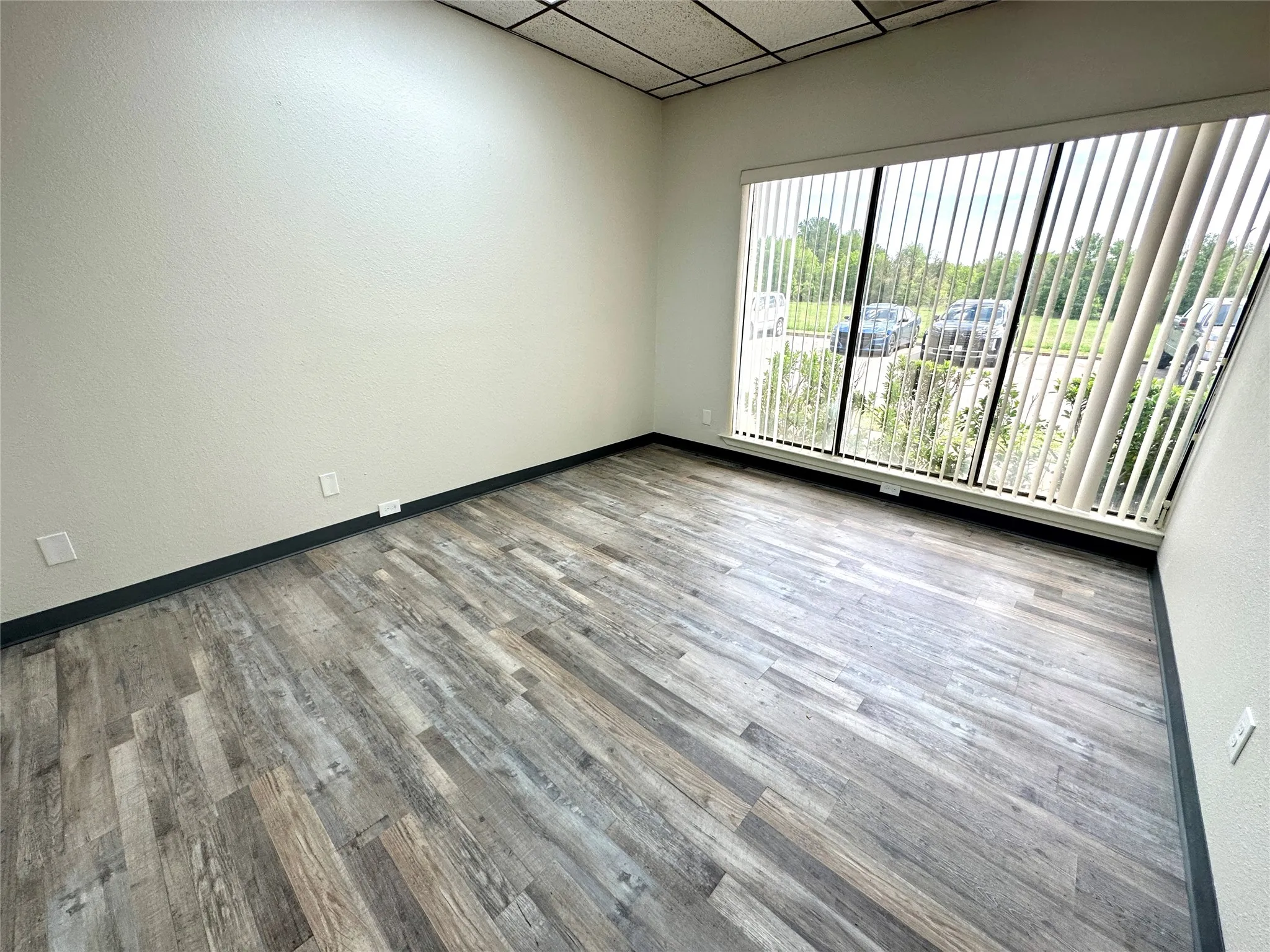Spare room with a paneled ceiling and wood-type flooring