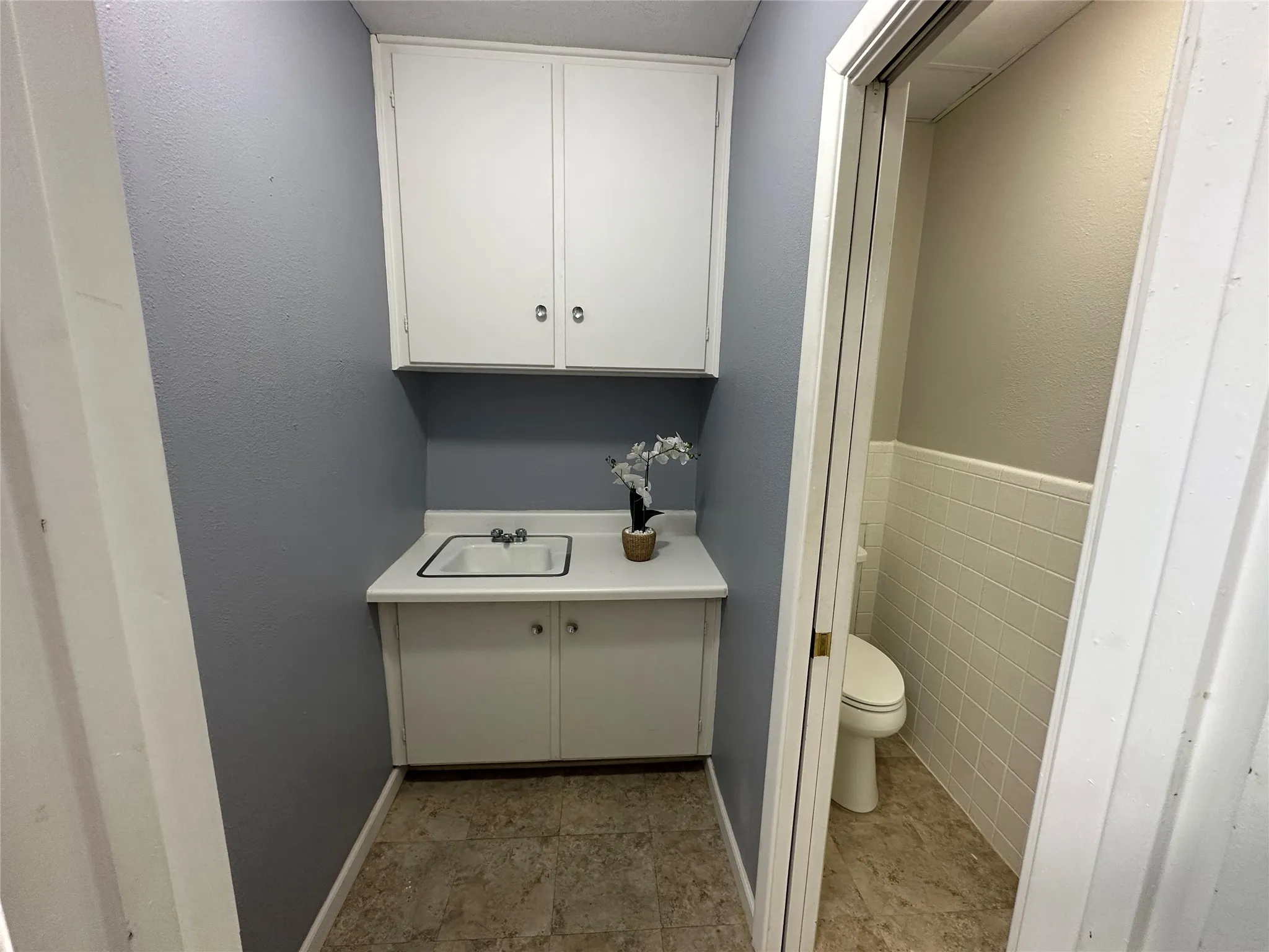 Bathroom with vanity, toilet, and tile patterned flooring