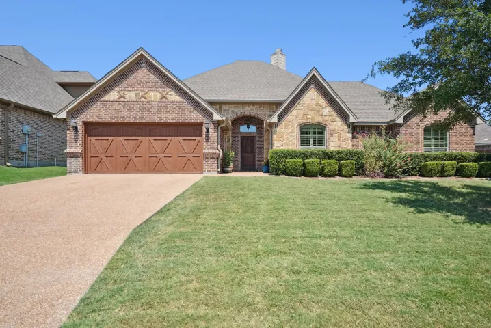View of front of home featuring a garage and a front lawn
