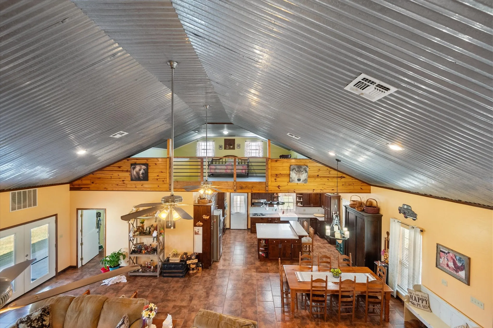Living room featuring ceiling fan, dark tile patterned flooring, and vaulted ceiling
