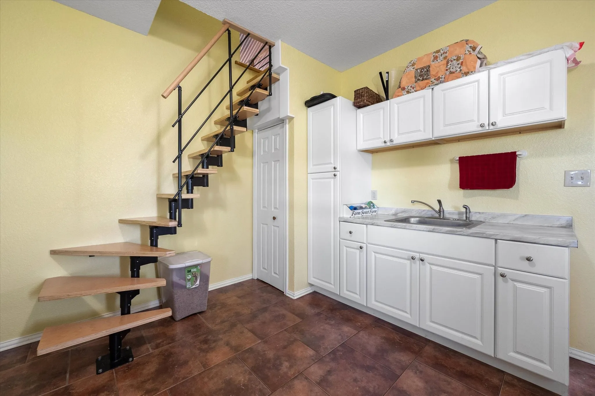 Kitchen with sink, white cabinets, and dark tile patterned flooring