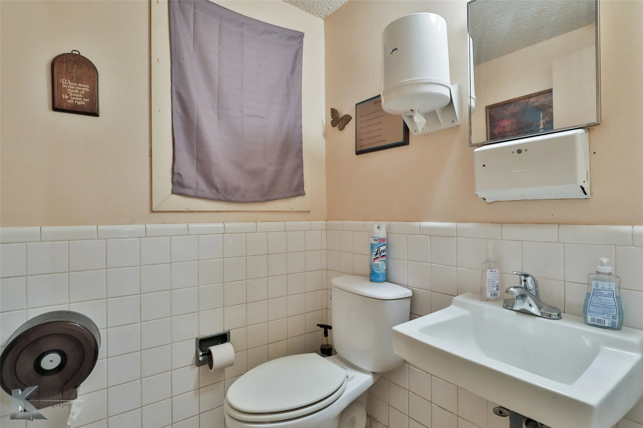 Bathroom with tile walls and a textured ceiling