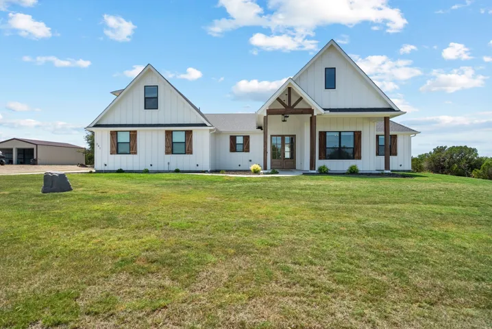Modern farmhouse style home with a front yard