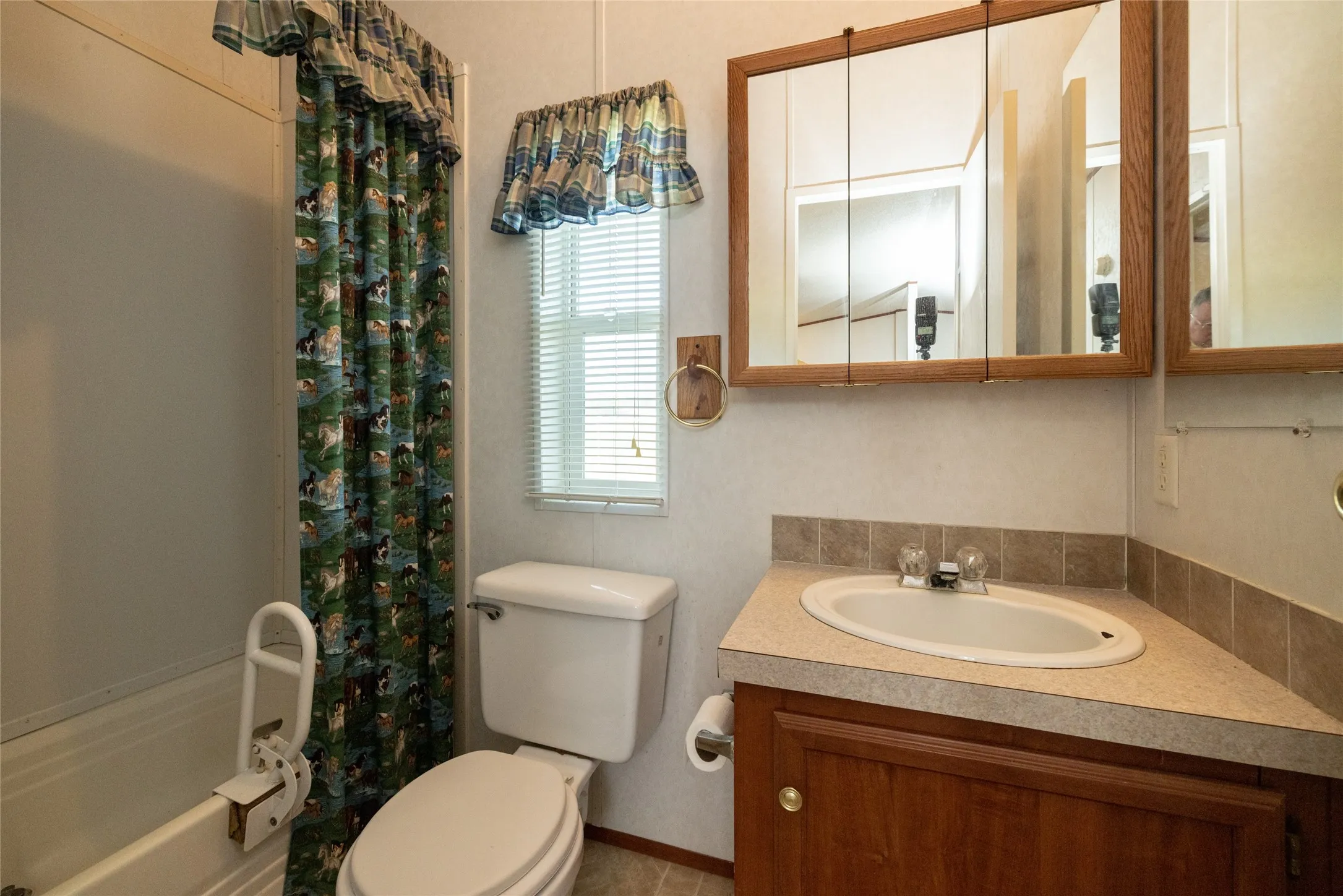 Full bathroom featuring shower / tub combo with curtain, toilet, and vanity
