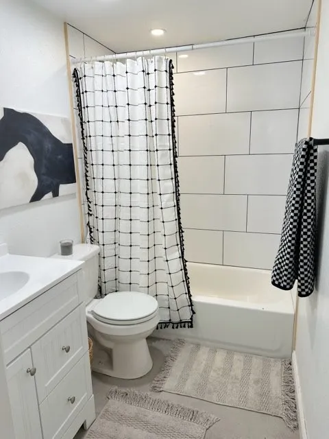 Full bathroom featuring vanity, toilet, and shower / tub combo