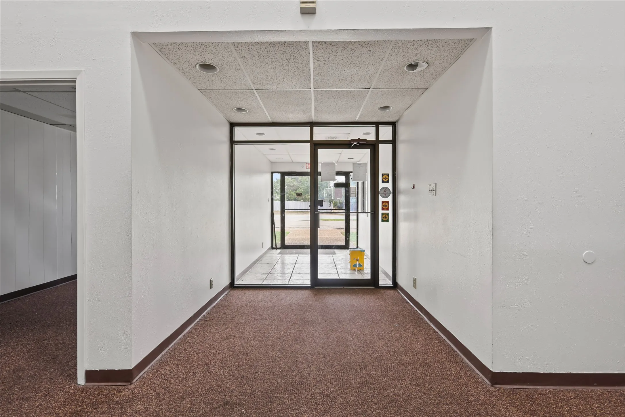 Well lit double entry with tiled floor.