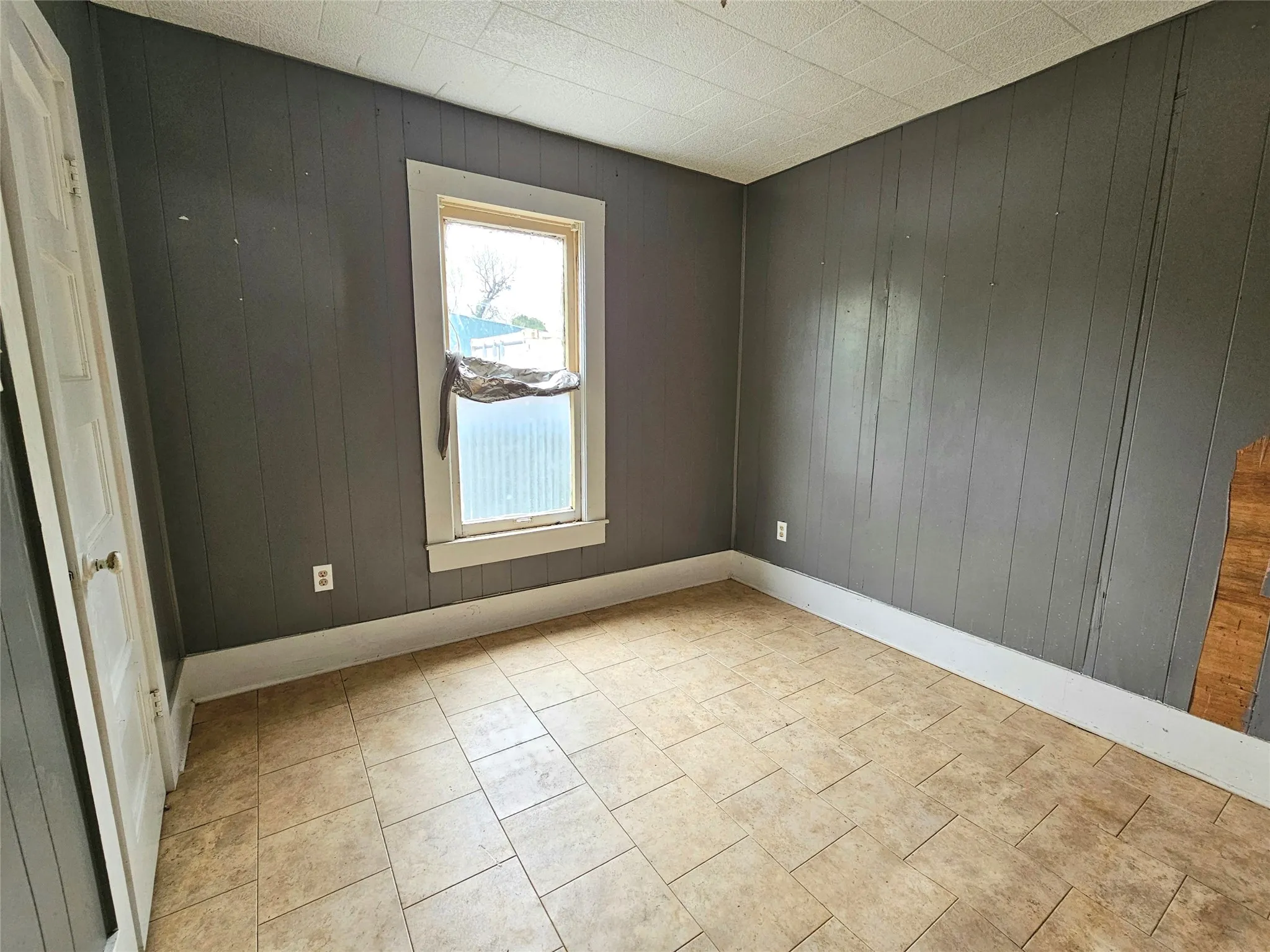 Empty room featuring light tile patterned floors and baseboards