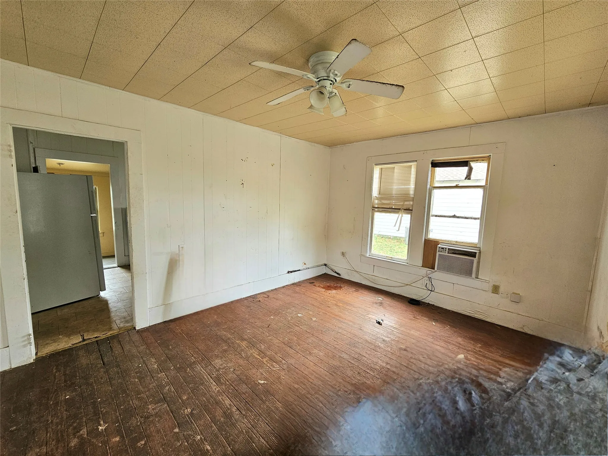 Empty room with cooling unit, hardwood / wood-style floors, and a ceiling fan