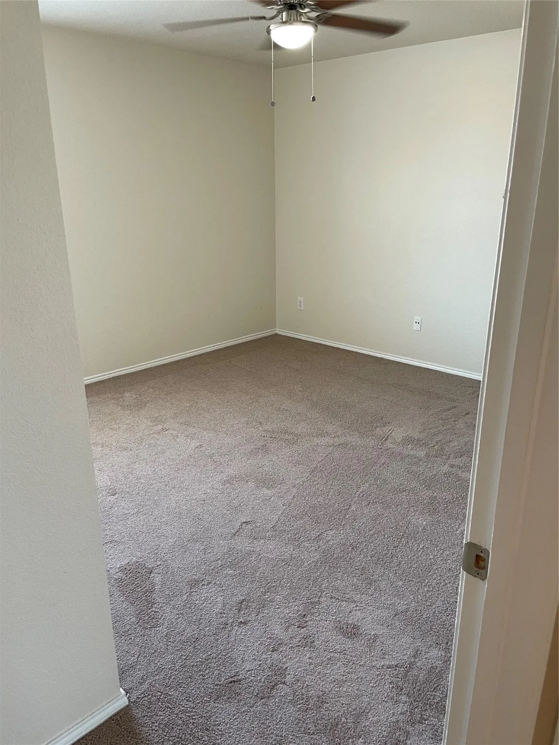 Spare room with ceiling fan and carpet