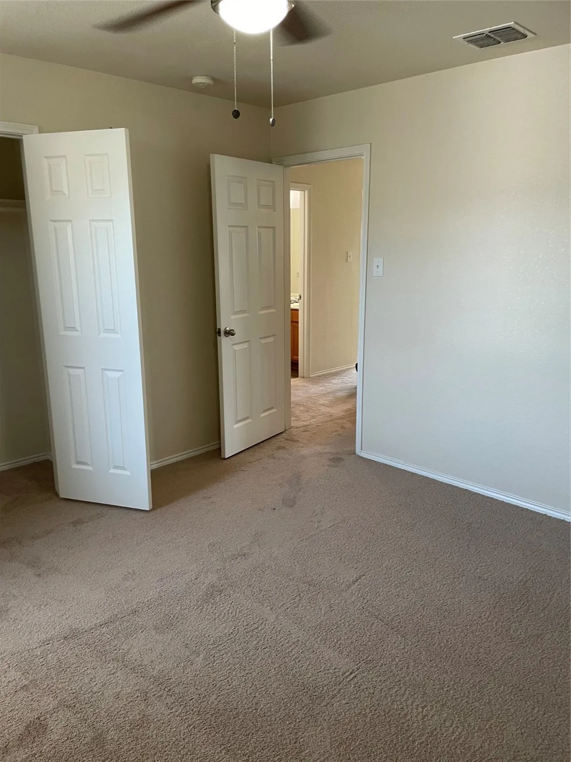 Unfurnished bedroom featuring ceiling fan and light carpet