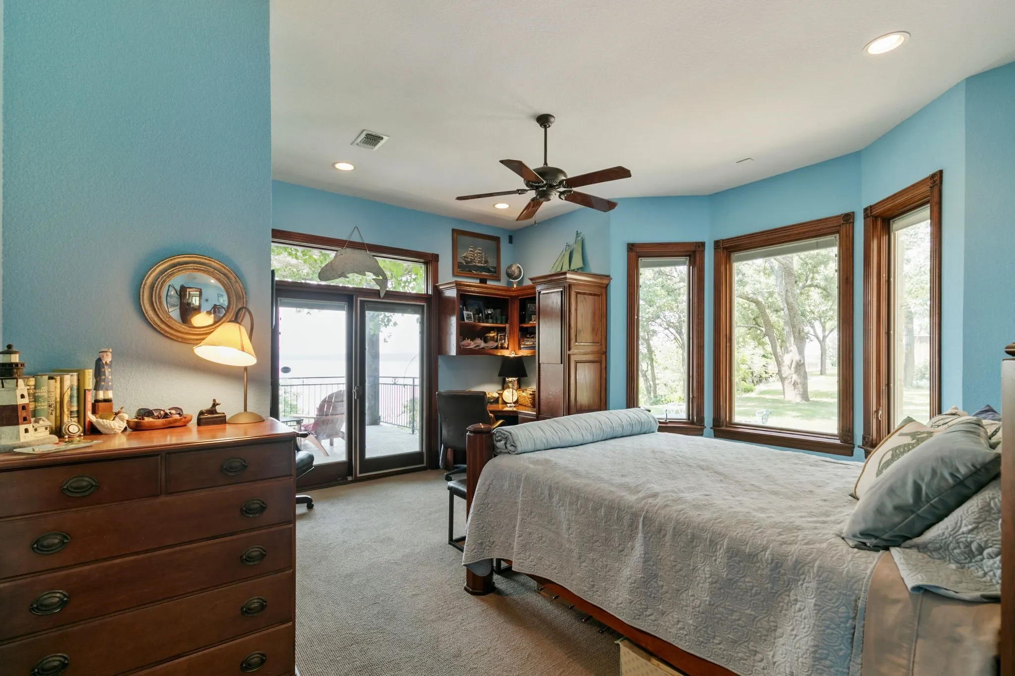 Bedroom featuring multiple windows, ceiling fan, light colored carpet, and access to exterior