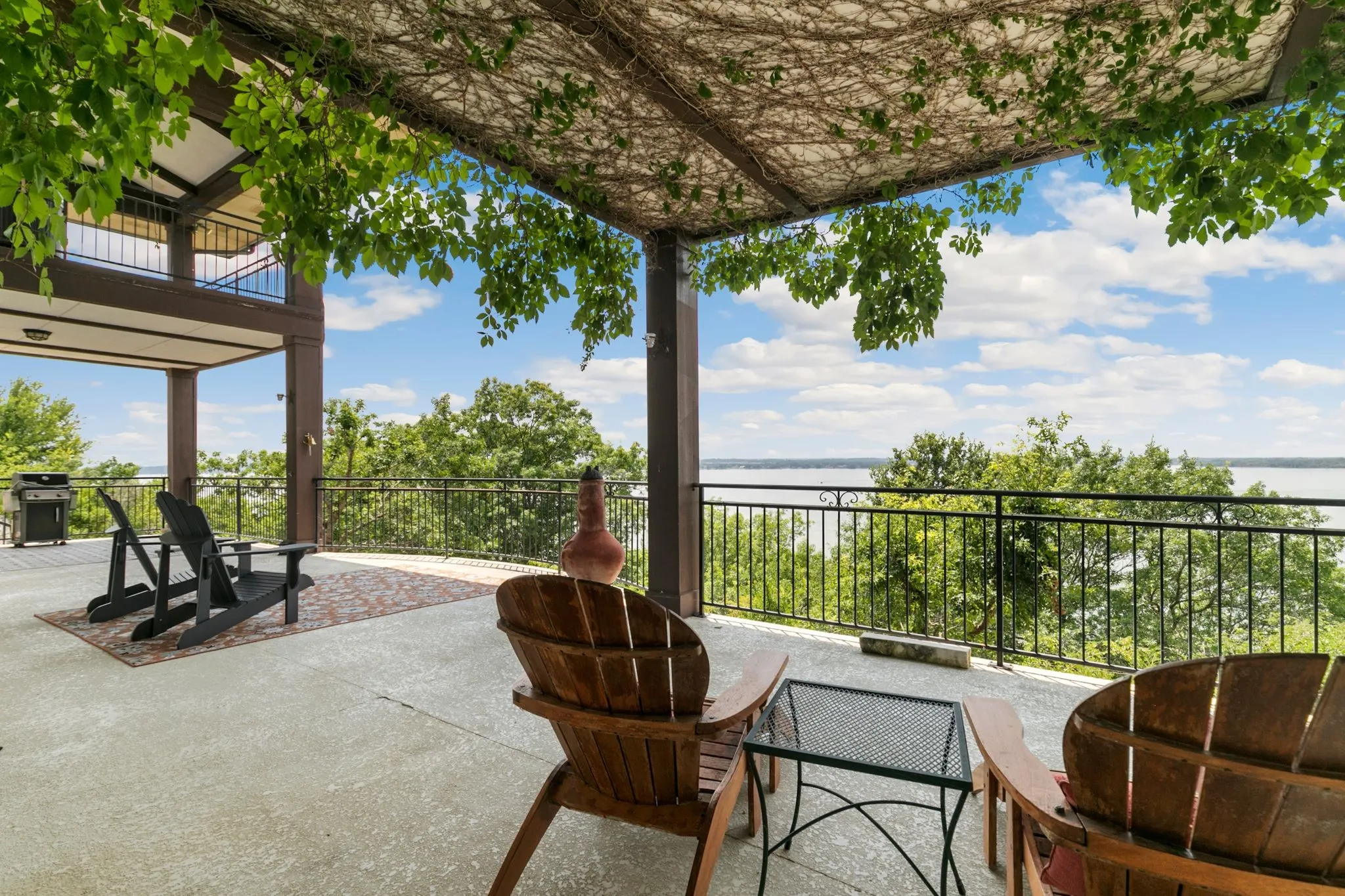 View of patio with a water view, area for grilling, and a balcony