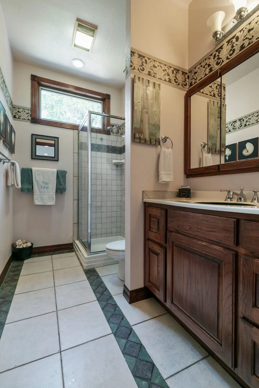 Bathroom with vanity, toilet, walk in shower, and tile patterned floors