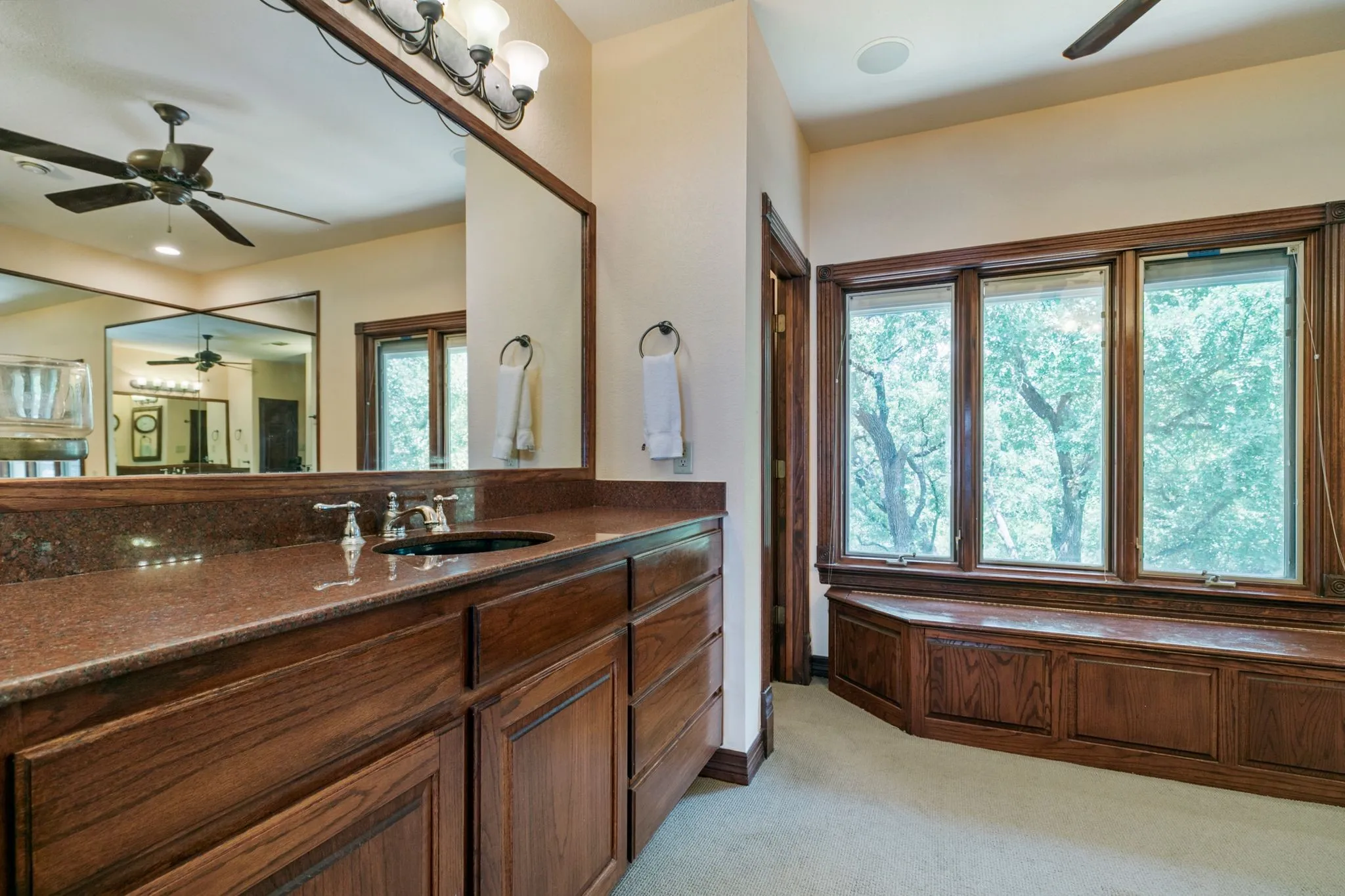 Bathroom with a bath, ceiling fan, a wealth of natural light, and vanity