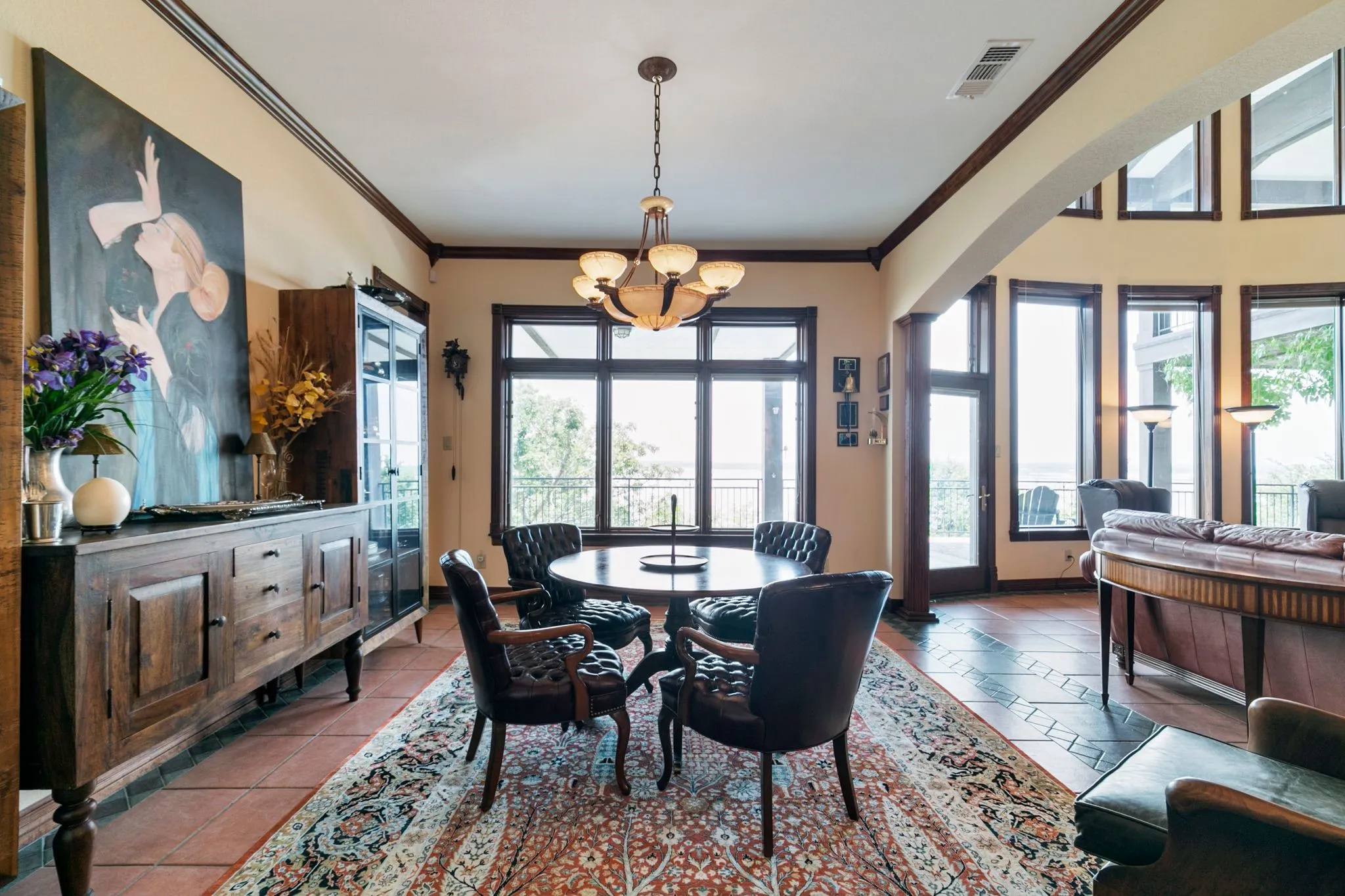 Tiled dining room with a wealth of natural light, a chandelier, and ornamental molding