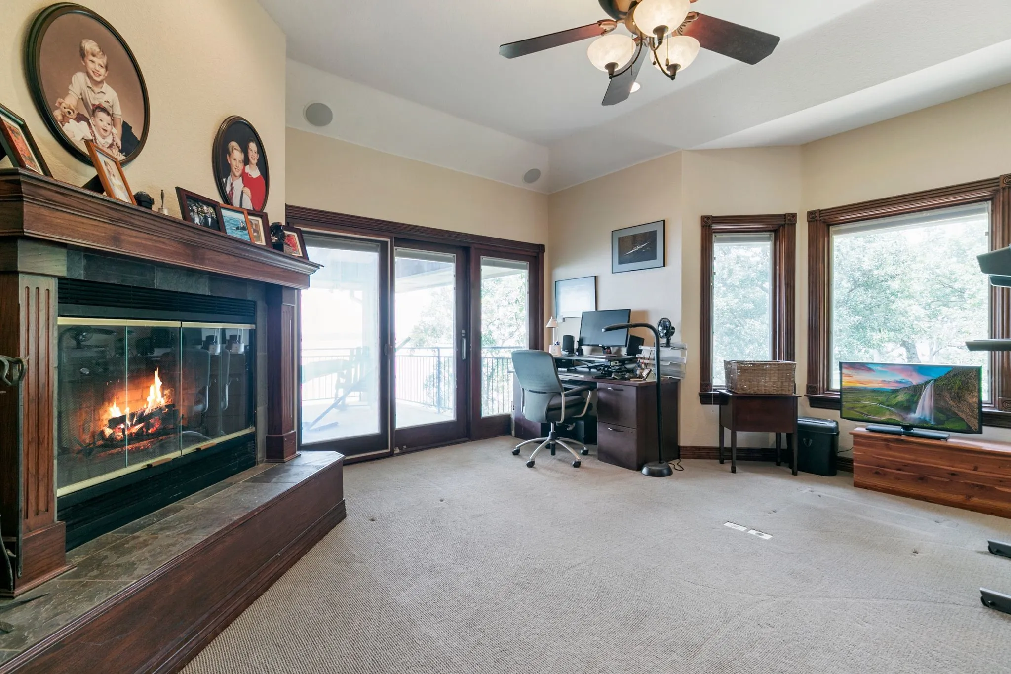 Carpeted home office with lofted ceiling and ceiling fan
