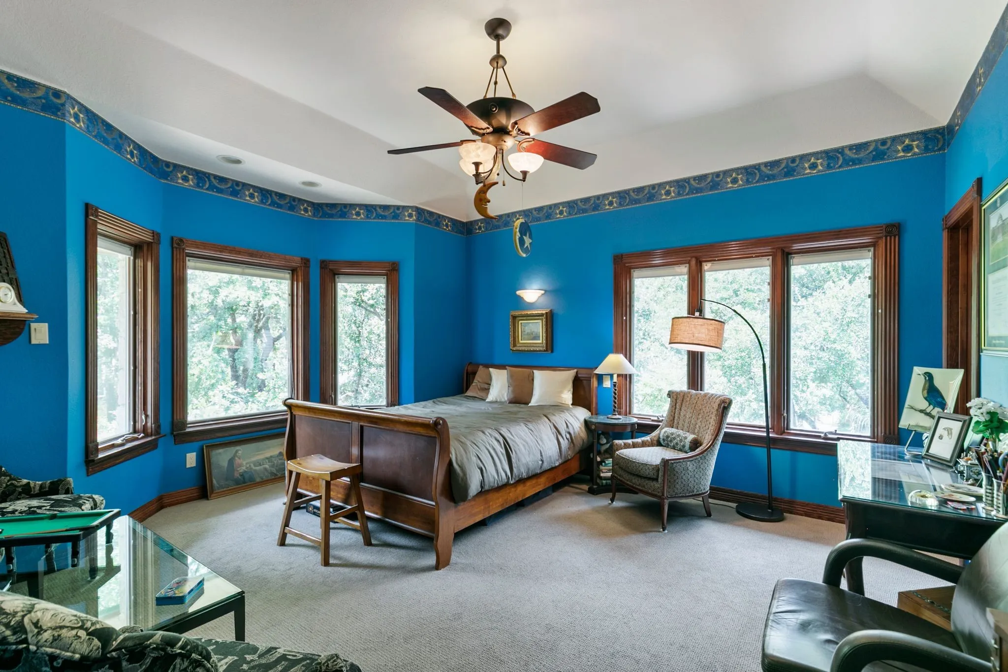 Bedroom with multiple windows, ceiling fan, and carpet floors