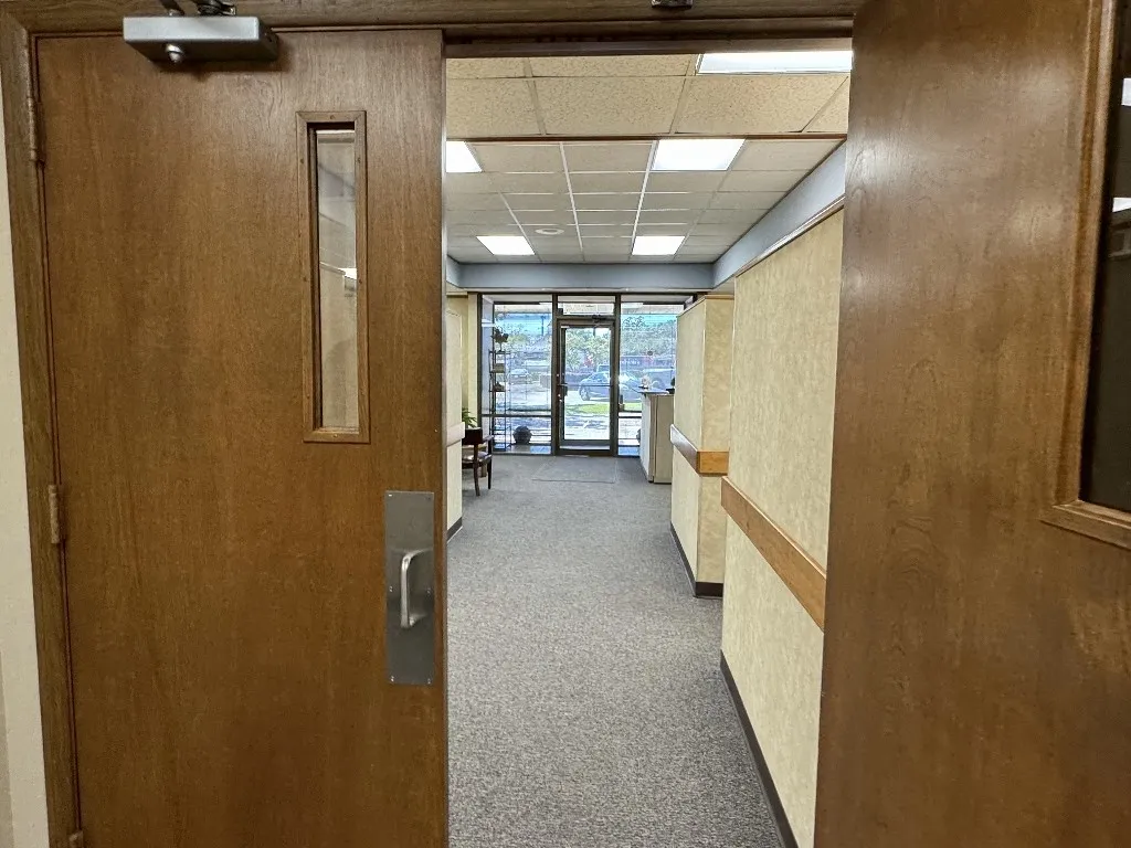 Corridor with carpet flooring and a paneled ceiling