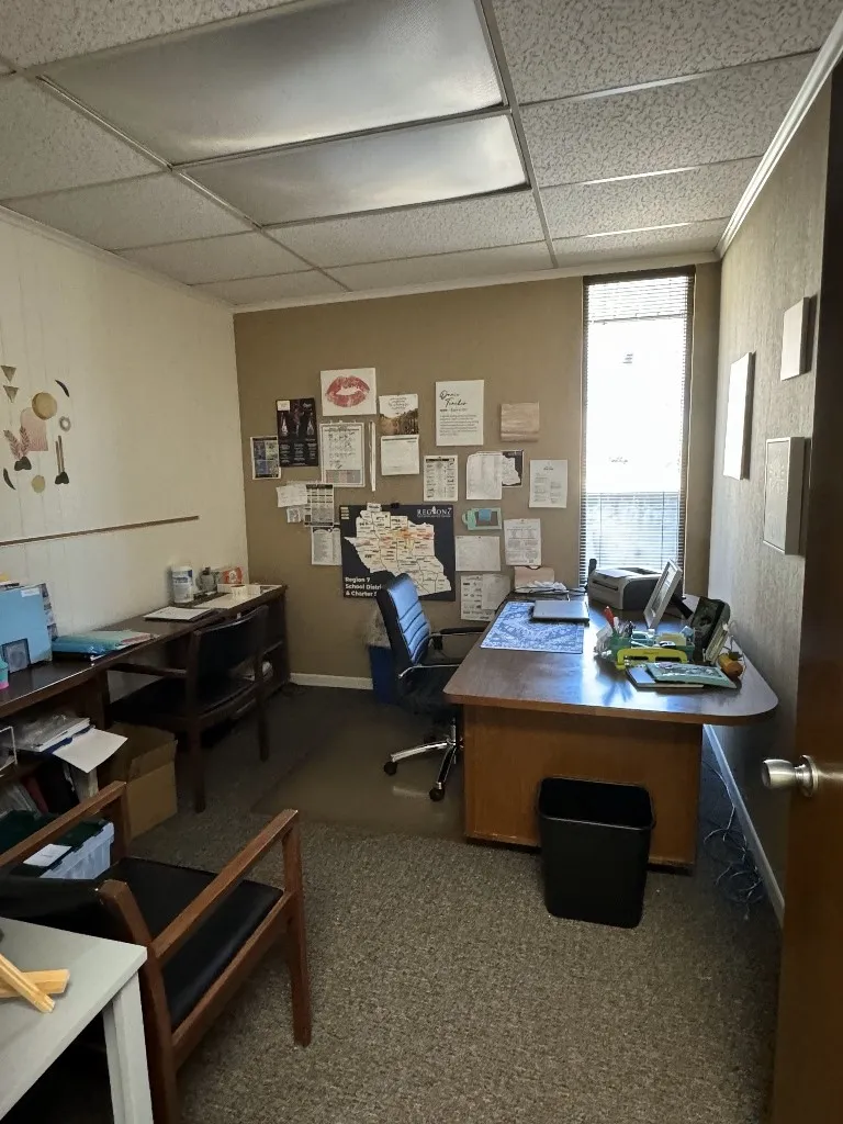Carpeted home office featuring a drop ceiling