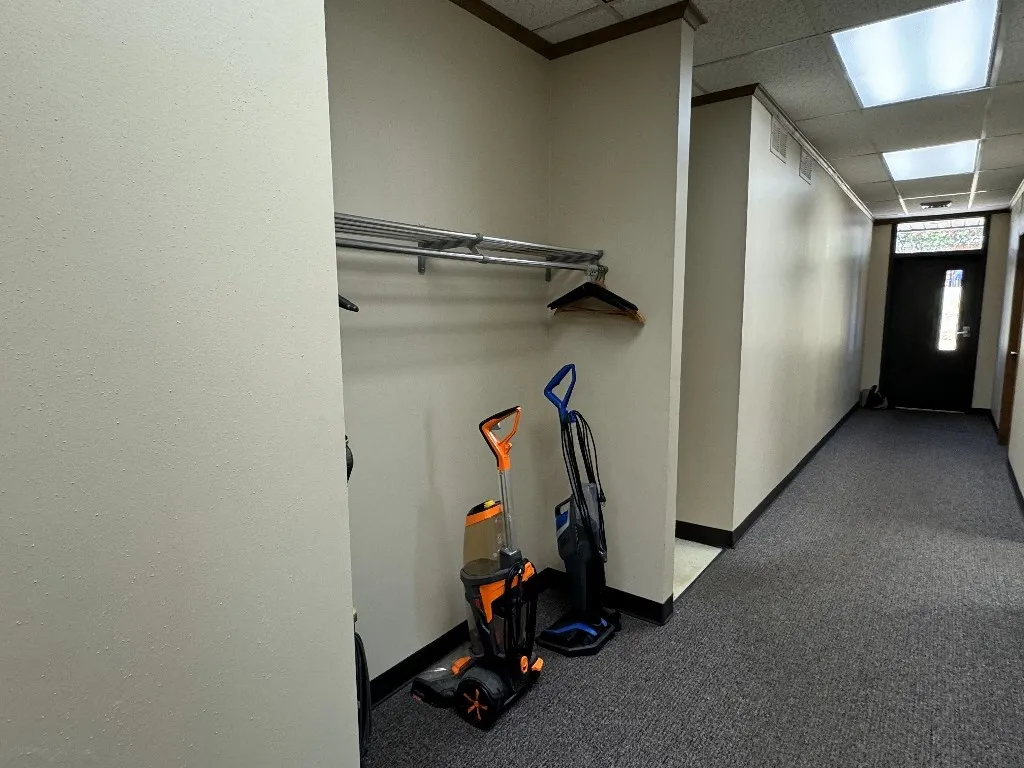 Hallway with a drop ceiling and carpet