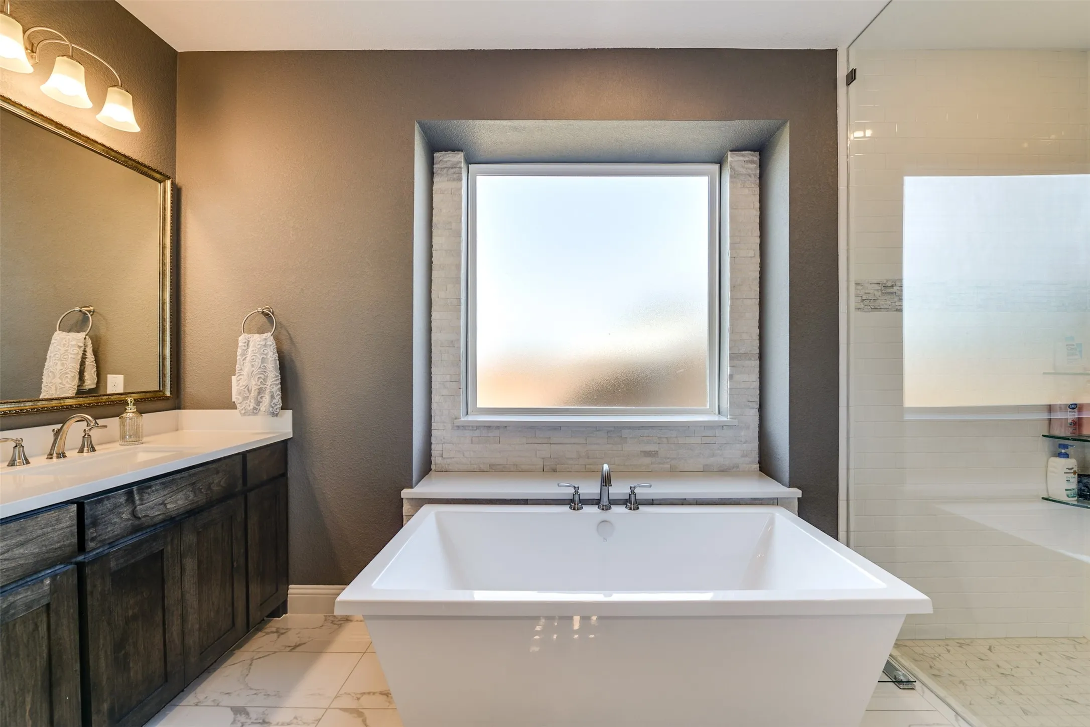 Bathroom featuring a tub to relax in and the other sink and vanity