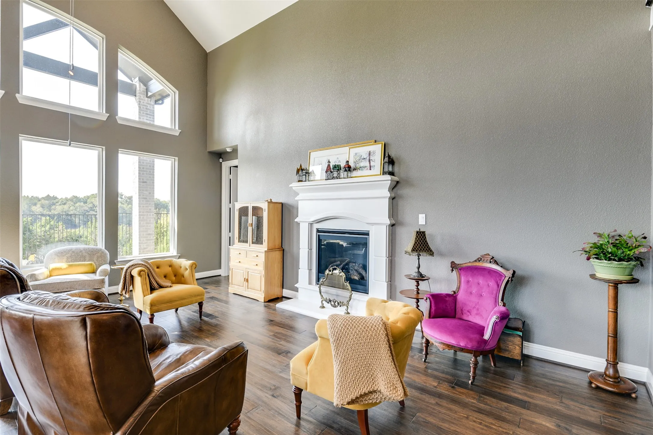 Living room with dark wood-type flooring and high vaulted ceiling.  Notice the views out the windows.
