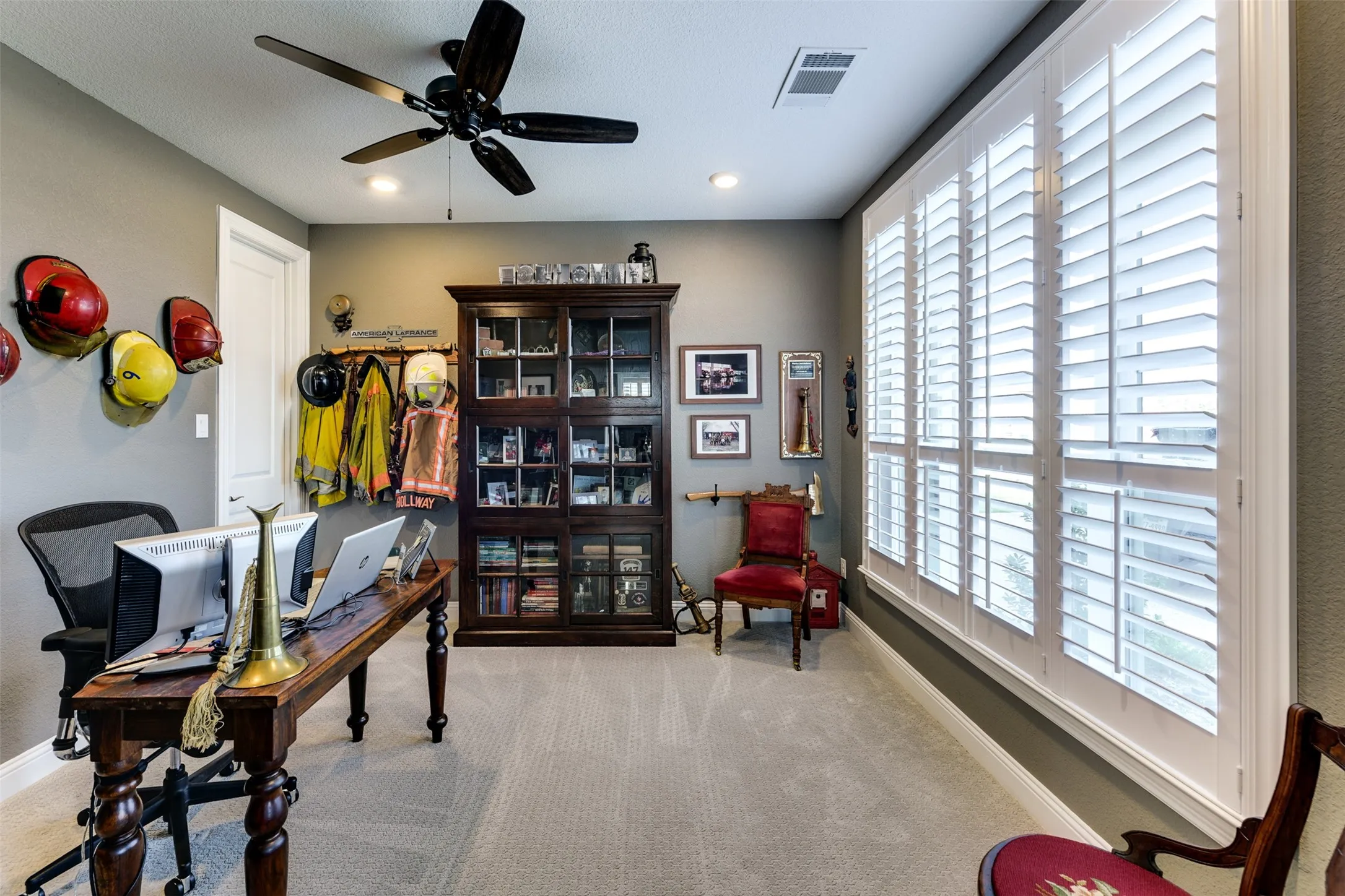 Office area featuring light carpet and ceiling fan.  This room has a closet, and is considered a bedroom.