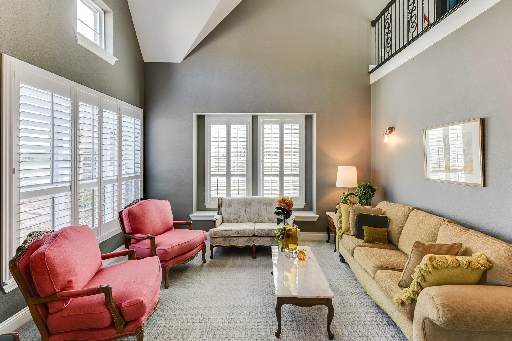 Carpeted living room featuring high vaulted ceiling.  Twenty foot ceilings open to the upstairs.