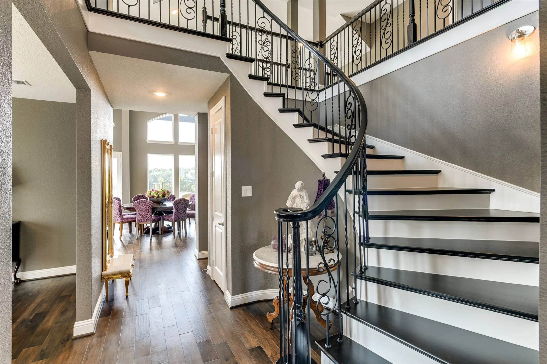 Stairway featuring wood-type flooring and a high ceiling.  Across from the formal dining area.
