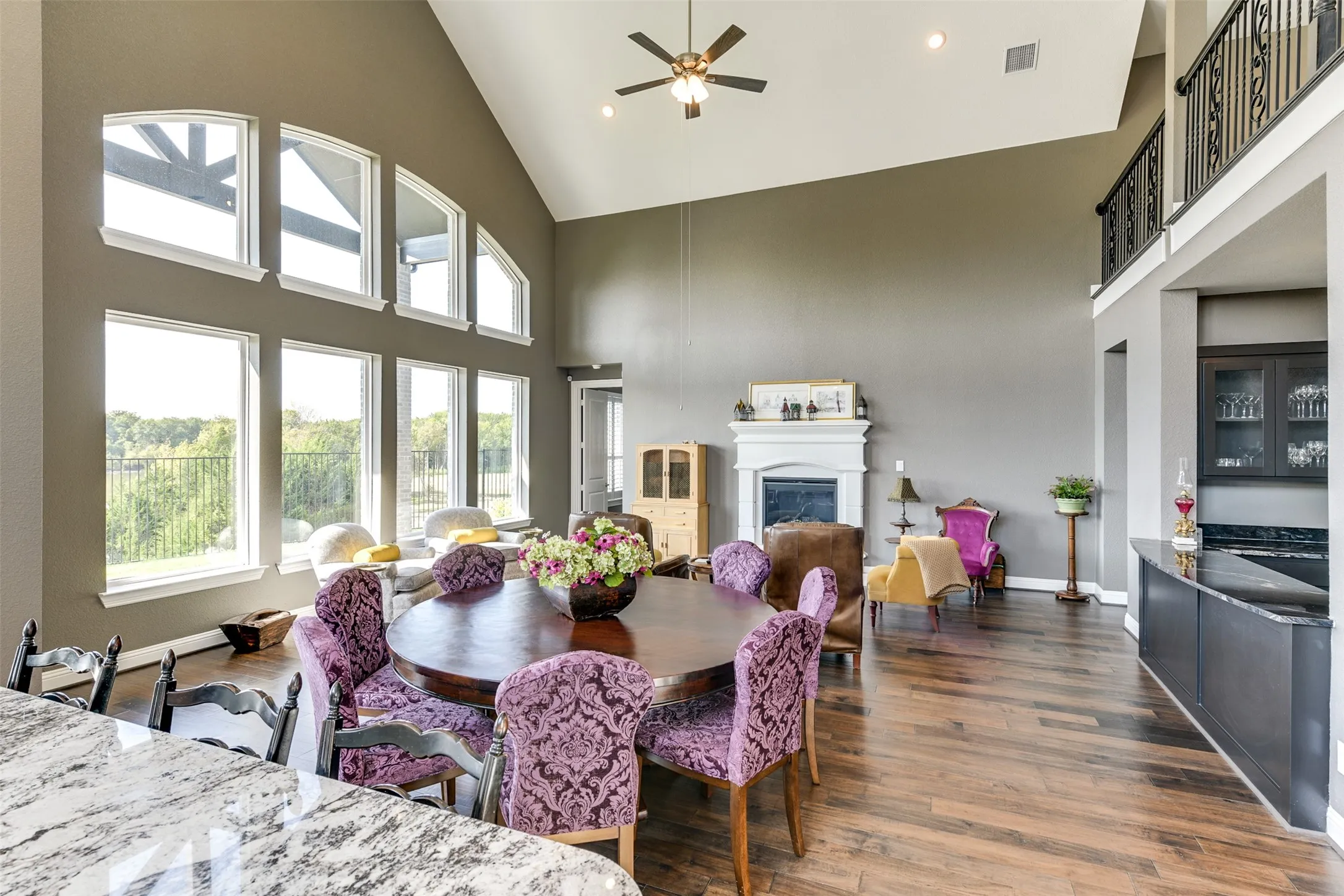 View of the rear of the property from the Dining room featuring ceiling fan, dark hardwood / wood-style flooring, and high vaulted ceiling