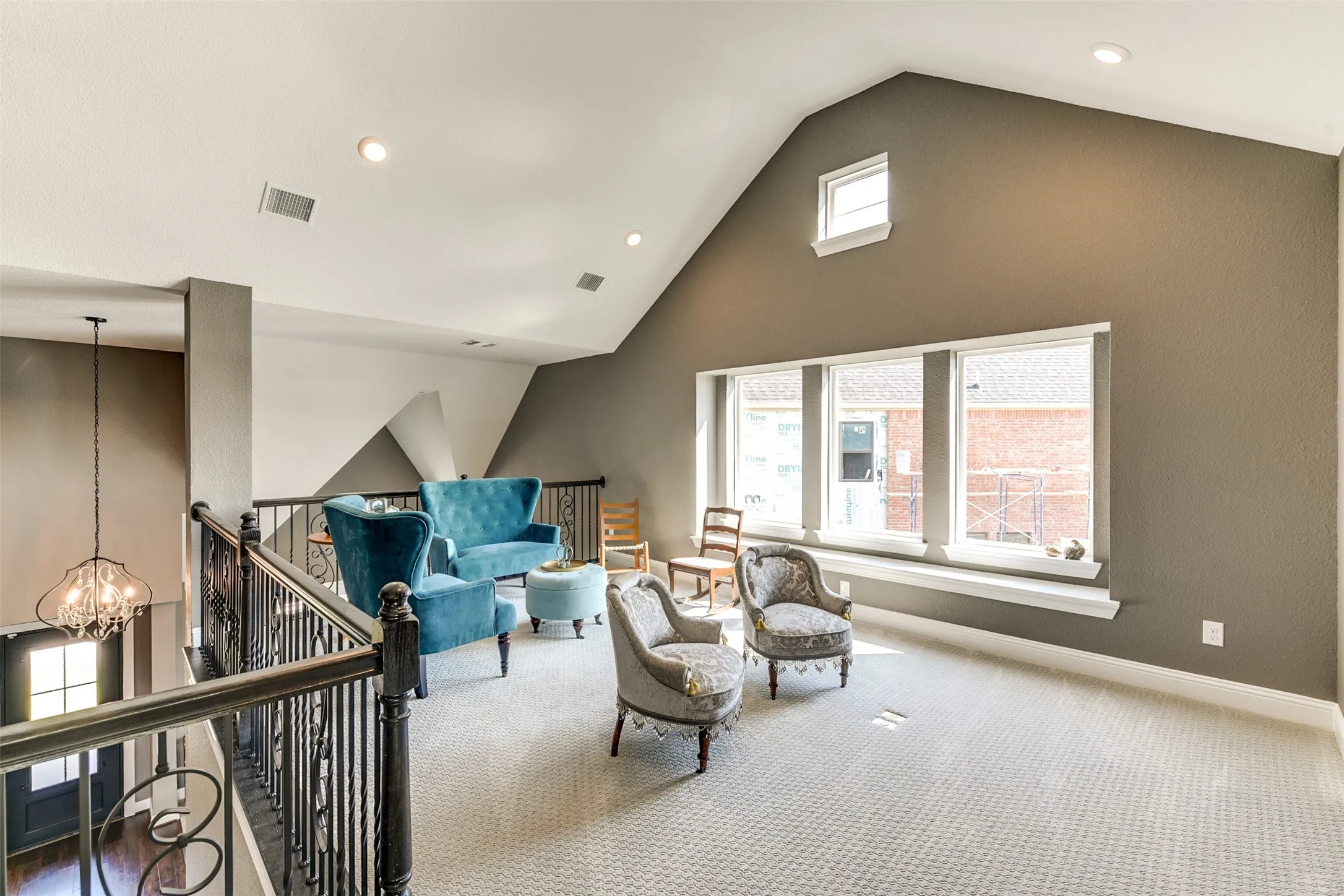 Loft area upstairs with an inviting chandelier, lofted ceiling, plenty of natural light, and carpet flooring.  This could be used as another family room.