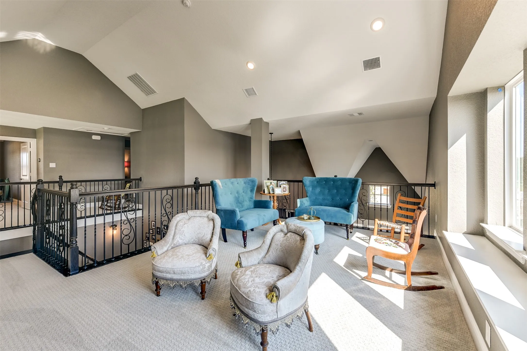 Living area with high vaulted ceiling and light colored carpet
