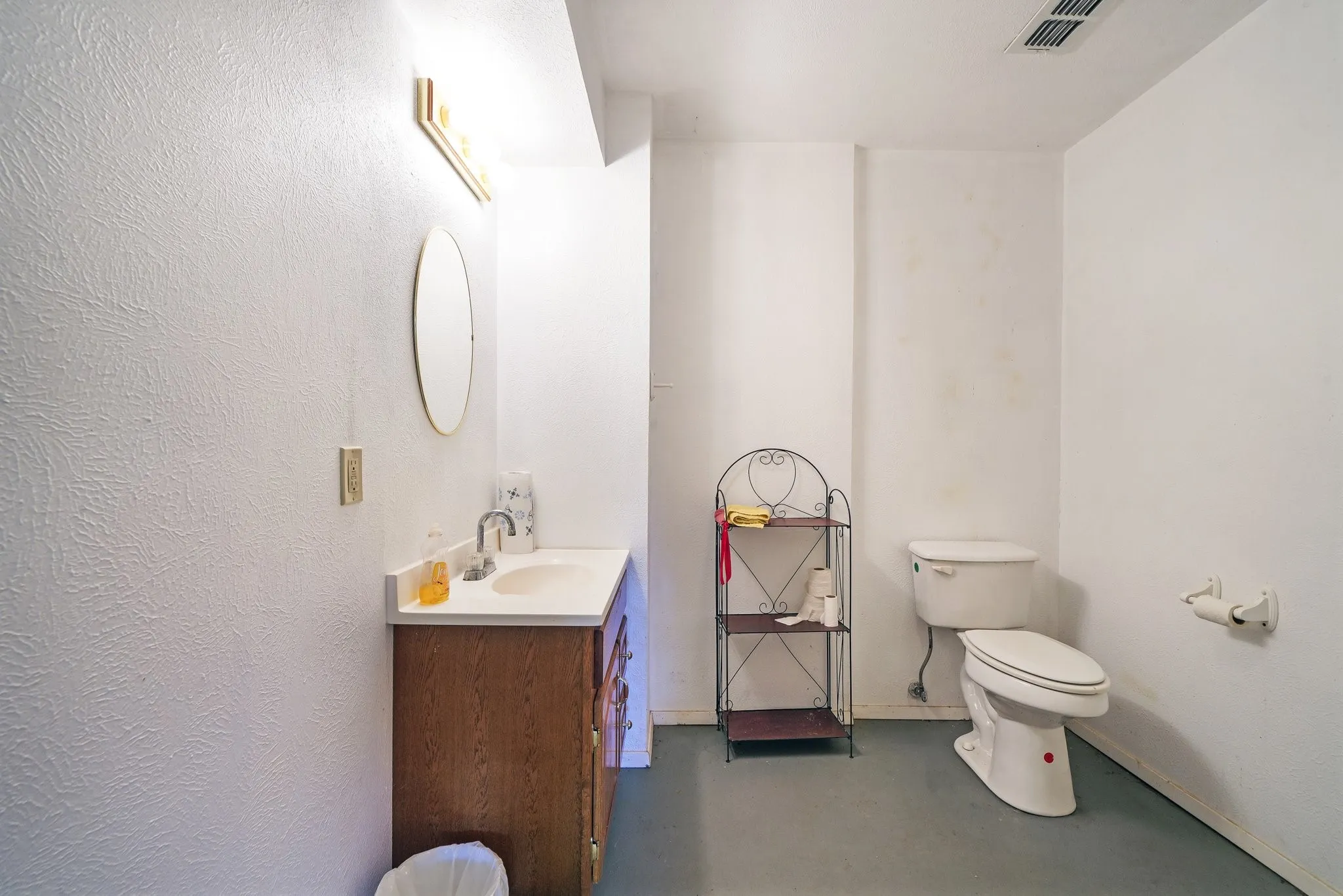 Bathroom with vanity, toilet, and concrete floors